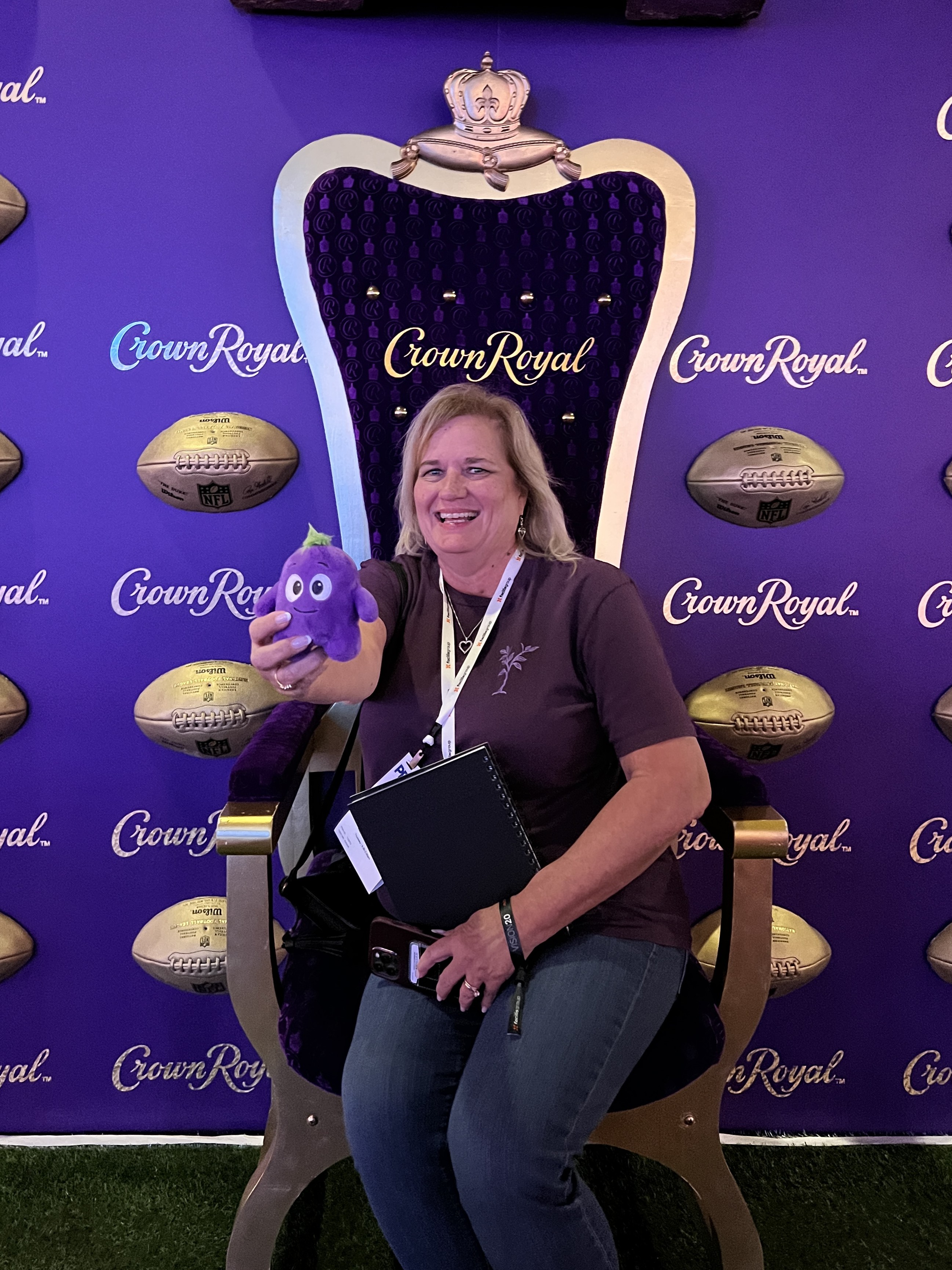Person sitting in a throne style chair with crown royal branding.